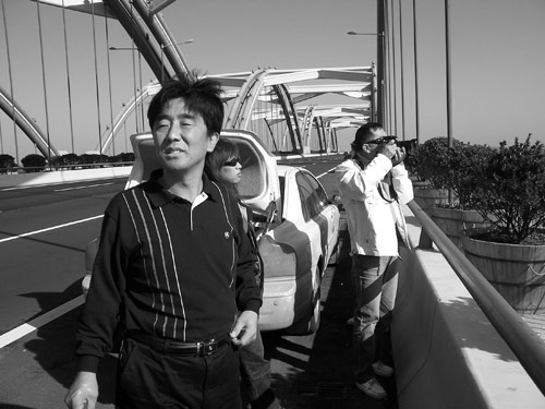 Zhu and others in his driving club pause to sightsee on a new bridge over the Yellow River.